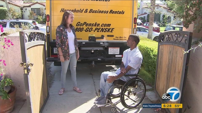 Furnishing Hope volunteer and wounded veteran beside a Penske moving truck