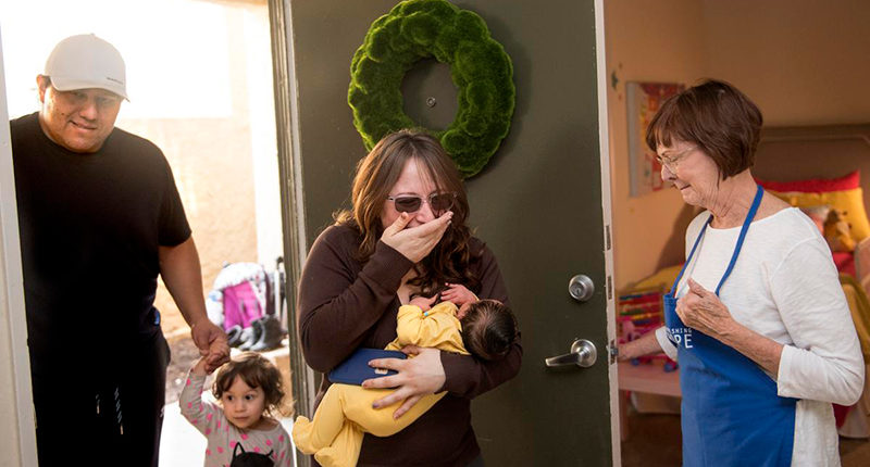 Family emotional at the doorway of their newly furnished home