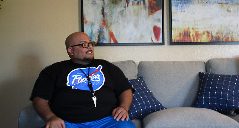 Sergeant Angel Alvarez sitting in his newly furnished apartment