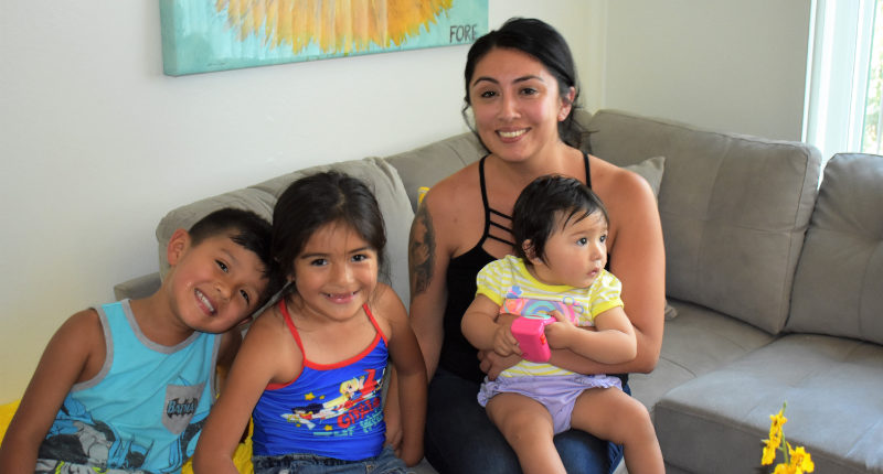Christine and her three children on their newly furnished sofa